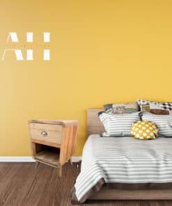 set of bedside drawers in natural wood next to a fully made bed