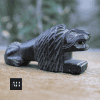 Side profile of antique stone lion showing cross hatched carved mane detail